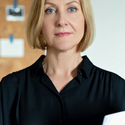 Professional headshot of a smiling, confident female mentor in a calm setting.